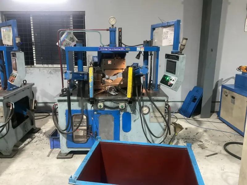 A blue hydraulic notching machine on the AR Automotive shop floor